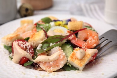 Photo of Delicious Caesar salad with shrimps on plate, closeup