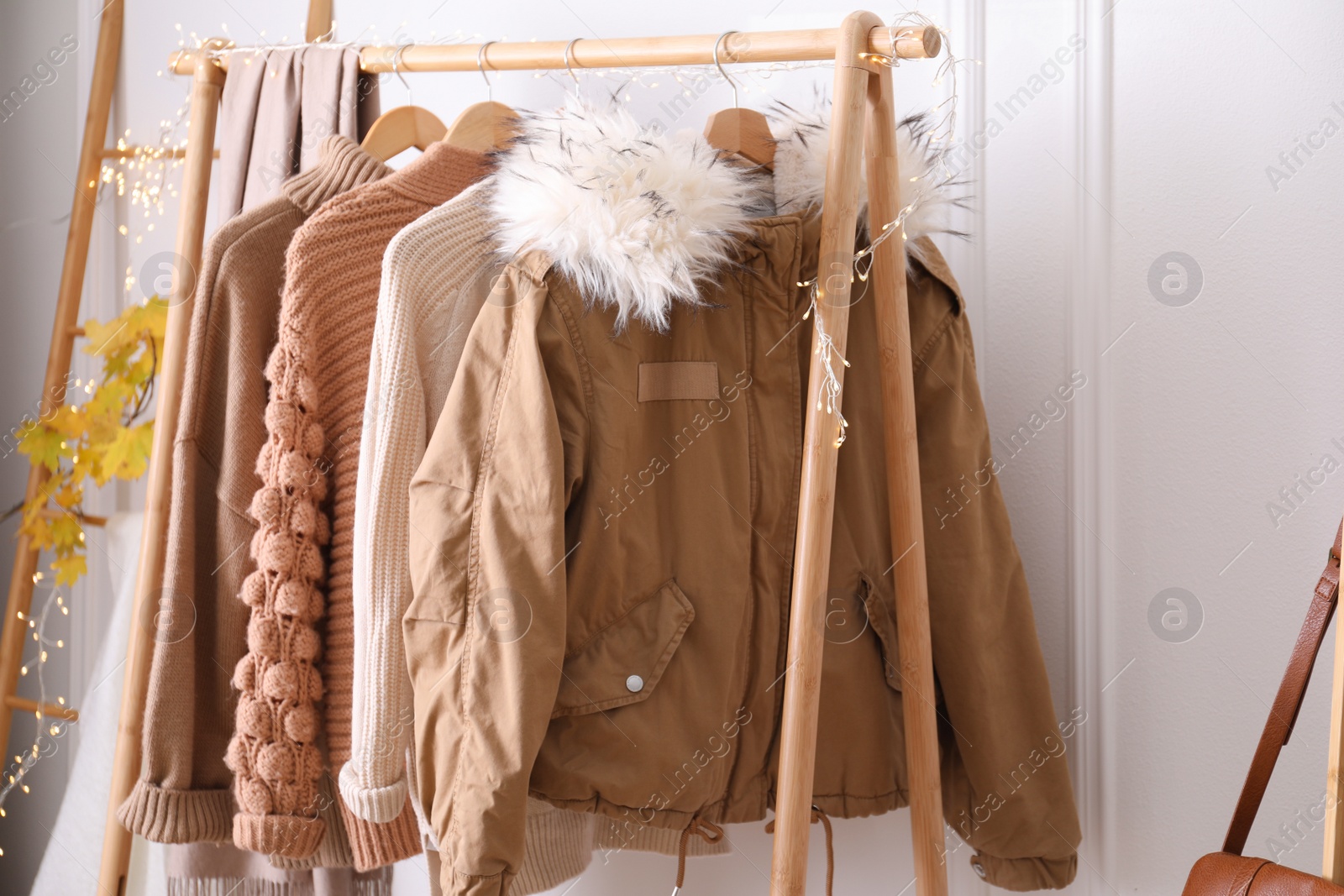 Photo of Rack with stylish warm clothes indoors, closeup