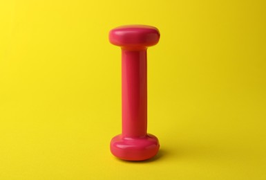Photo of Stylish dumbbell for exercise on yellow background