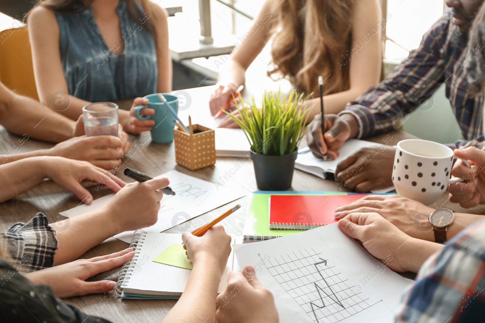 Photo of People working at table, closeup of hands. Unity concept