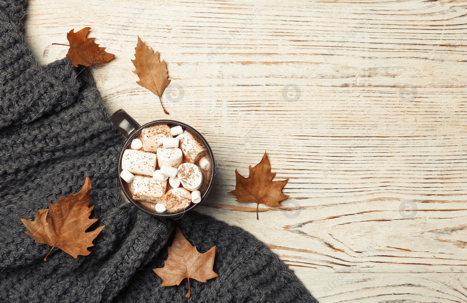 Photo of Flat lay composition with hot cozy drink and autumn leaves on wooden background. Space for text