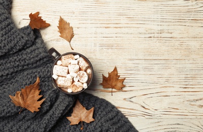 Photo of Flat lay composition with hot cozy drink and autumn leaves on wooden background. Space for text