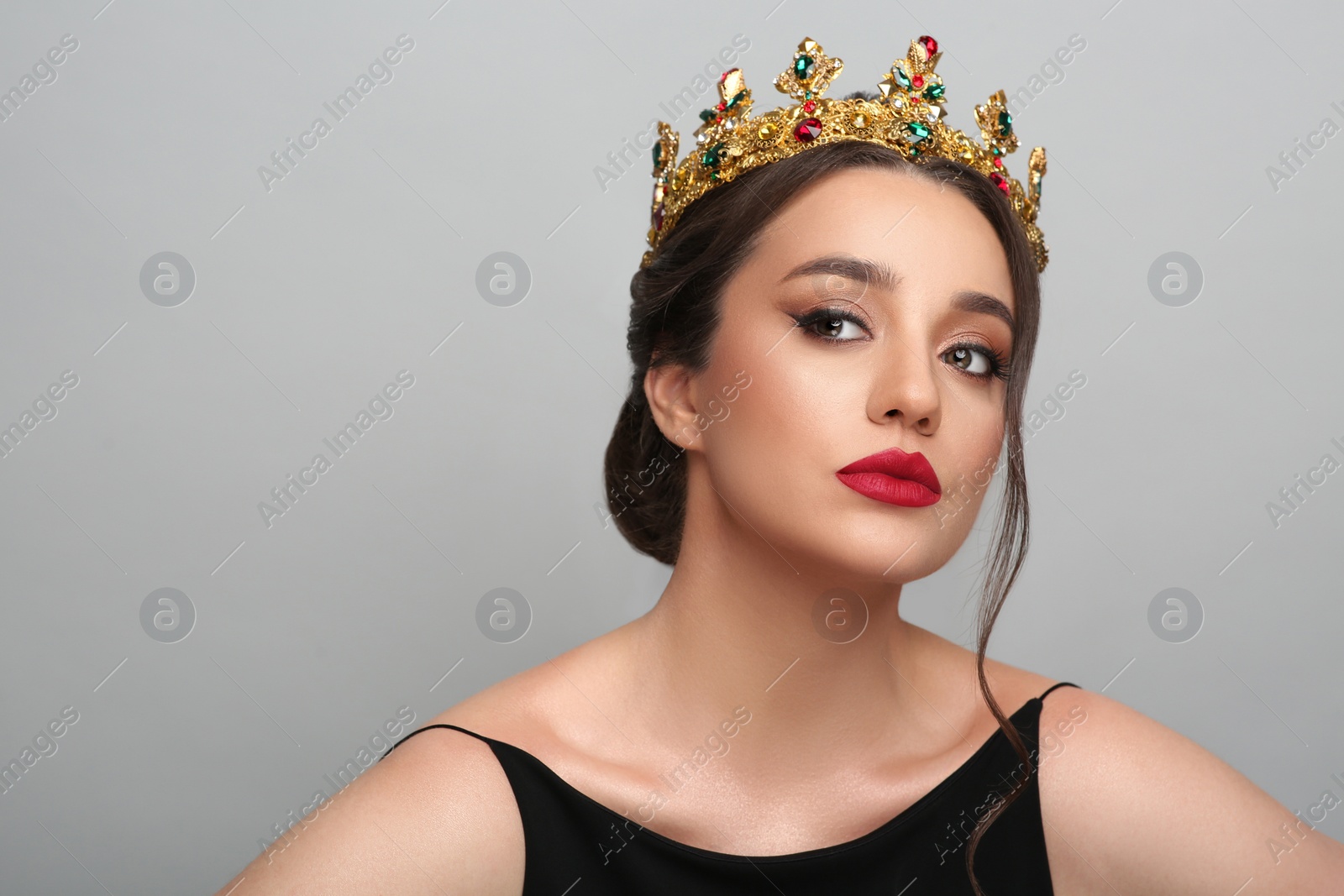 Photo of Beautiful young woman wearing luxurious crown on light grey background, space for text