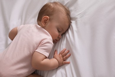 Photo of Adorable little baby sleeping on bed, above view. Space for text
