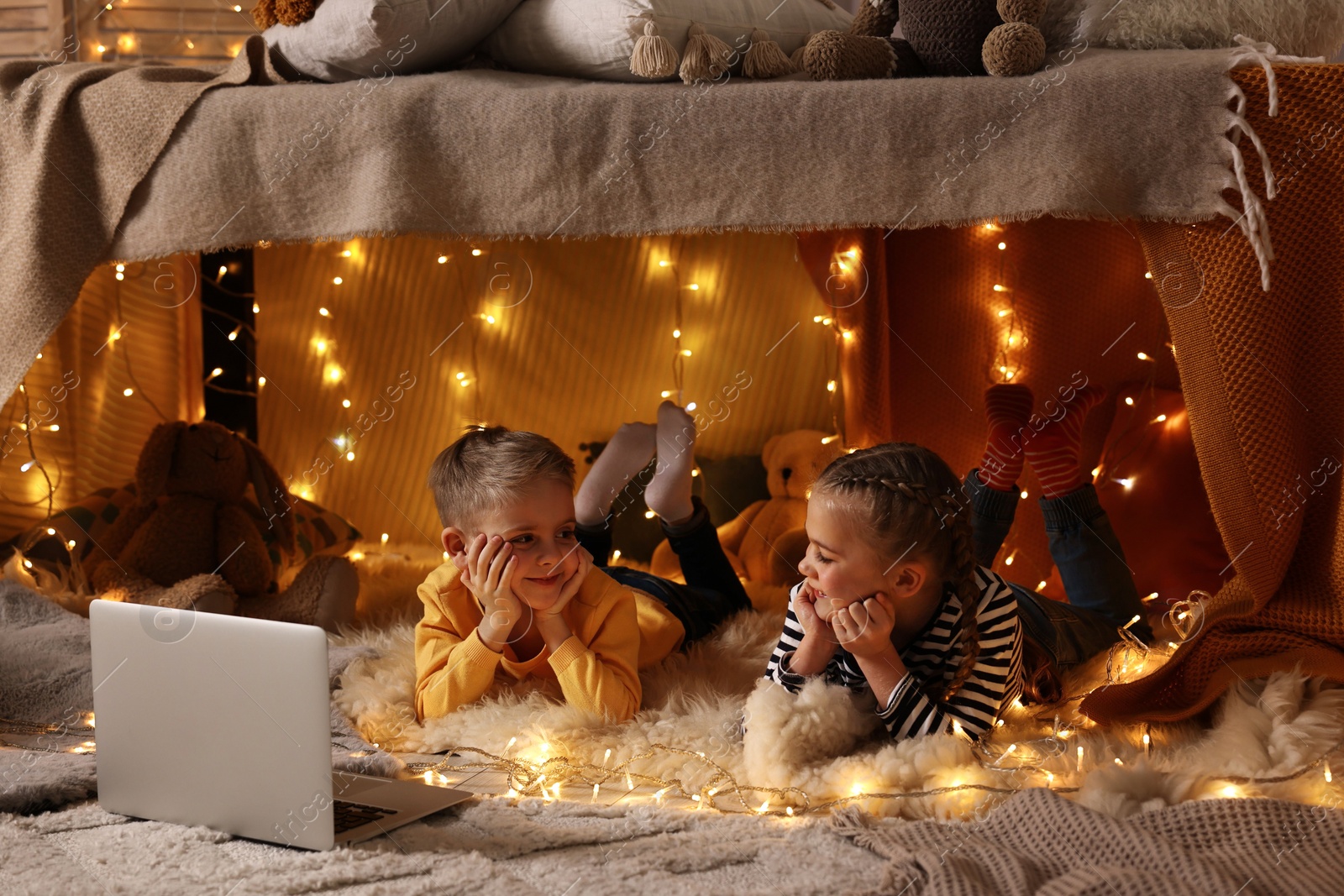 Photo of Kids with laptop in decorated play tent at home