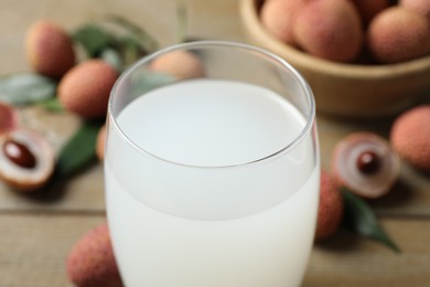 Glass with fresh lychee juice on table, closeup