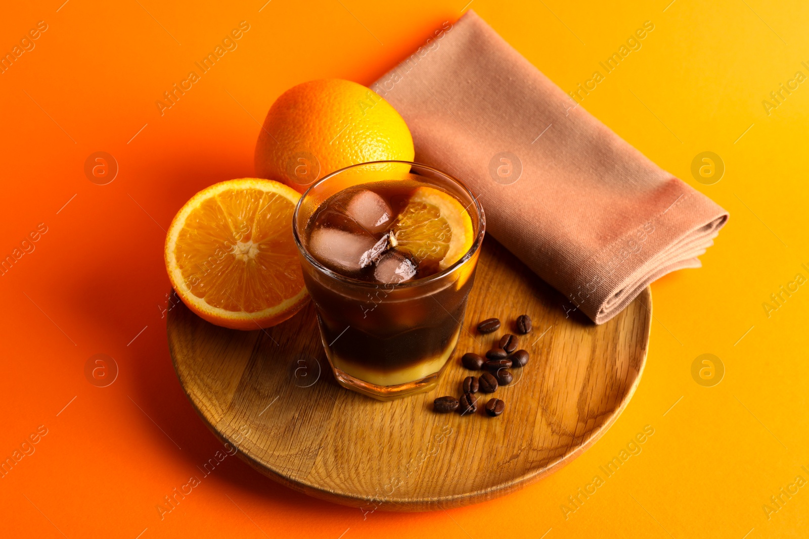 Photo of Tasty refreshing drink with coffee and orange juice on bright color background