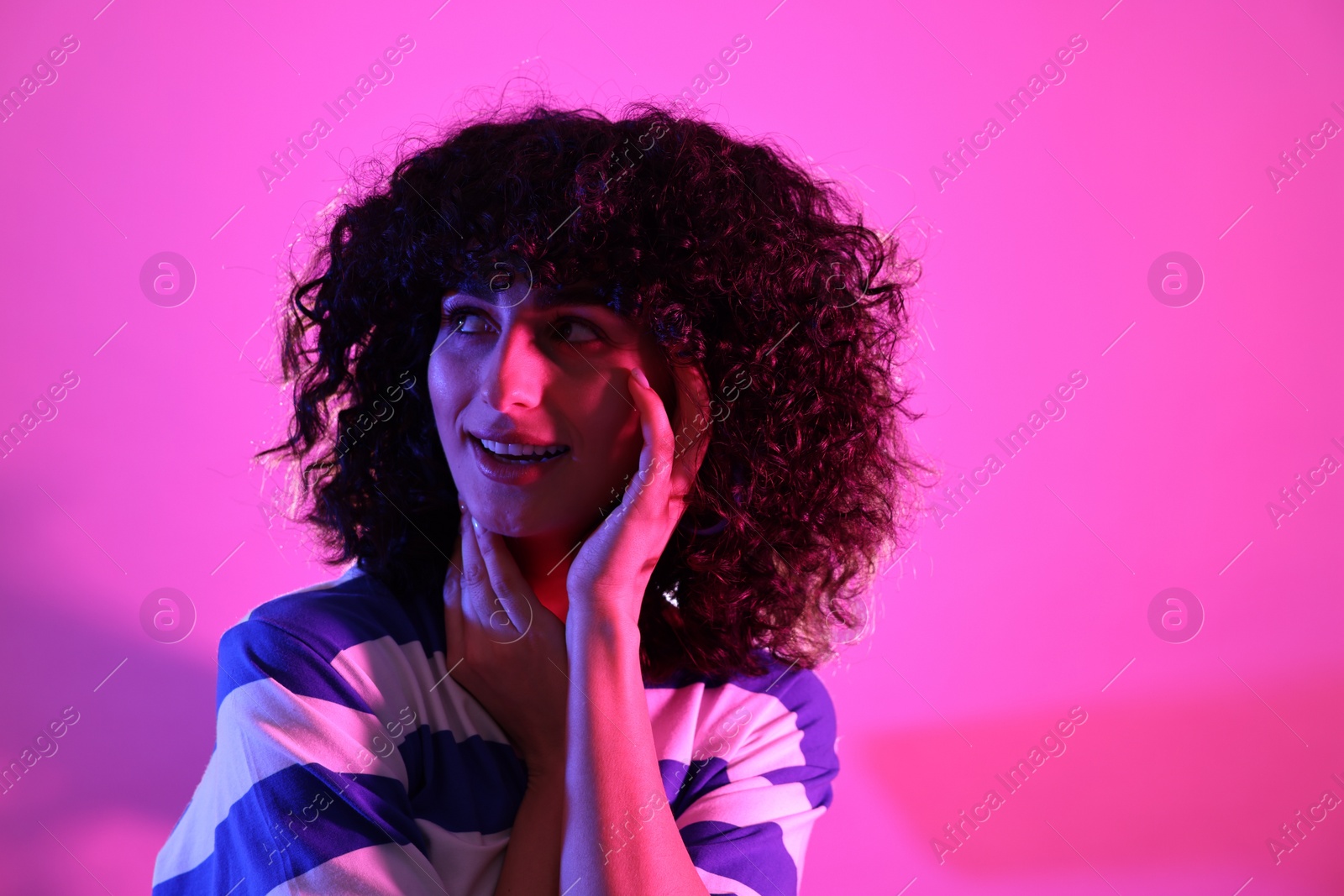 Photo of Beautiful young woman posing on color background in neon lights