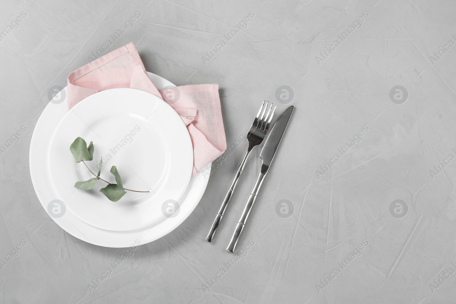 Photo of Stylish setting with elegant cutlery on grey table, top view. Space for text