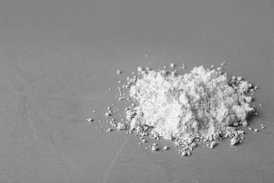 Photo of Heap of calcium carbonate powder on grey table. Space for text