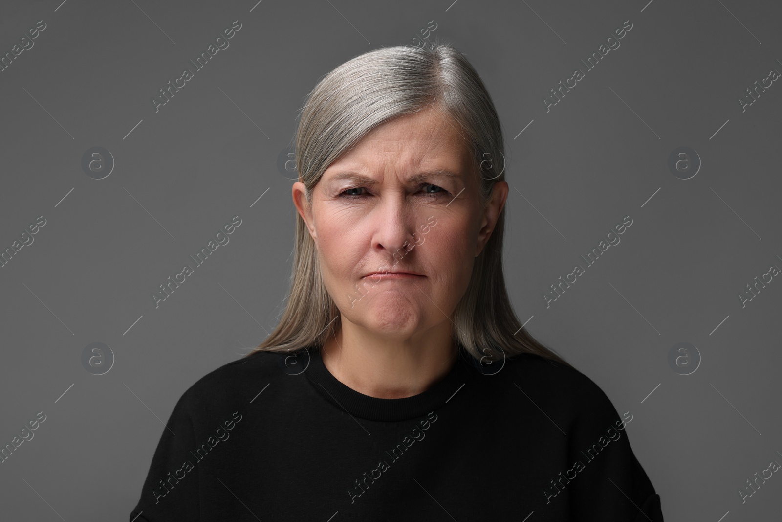 Photo of Personality concept. Portrait of emotional woman on gray background