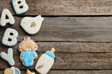 Word Baby and tasty cookies on wooden table, flat lay. Space for text