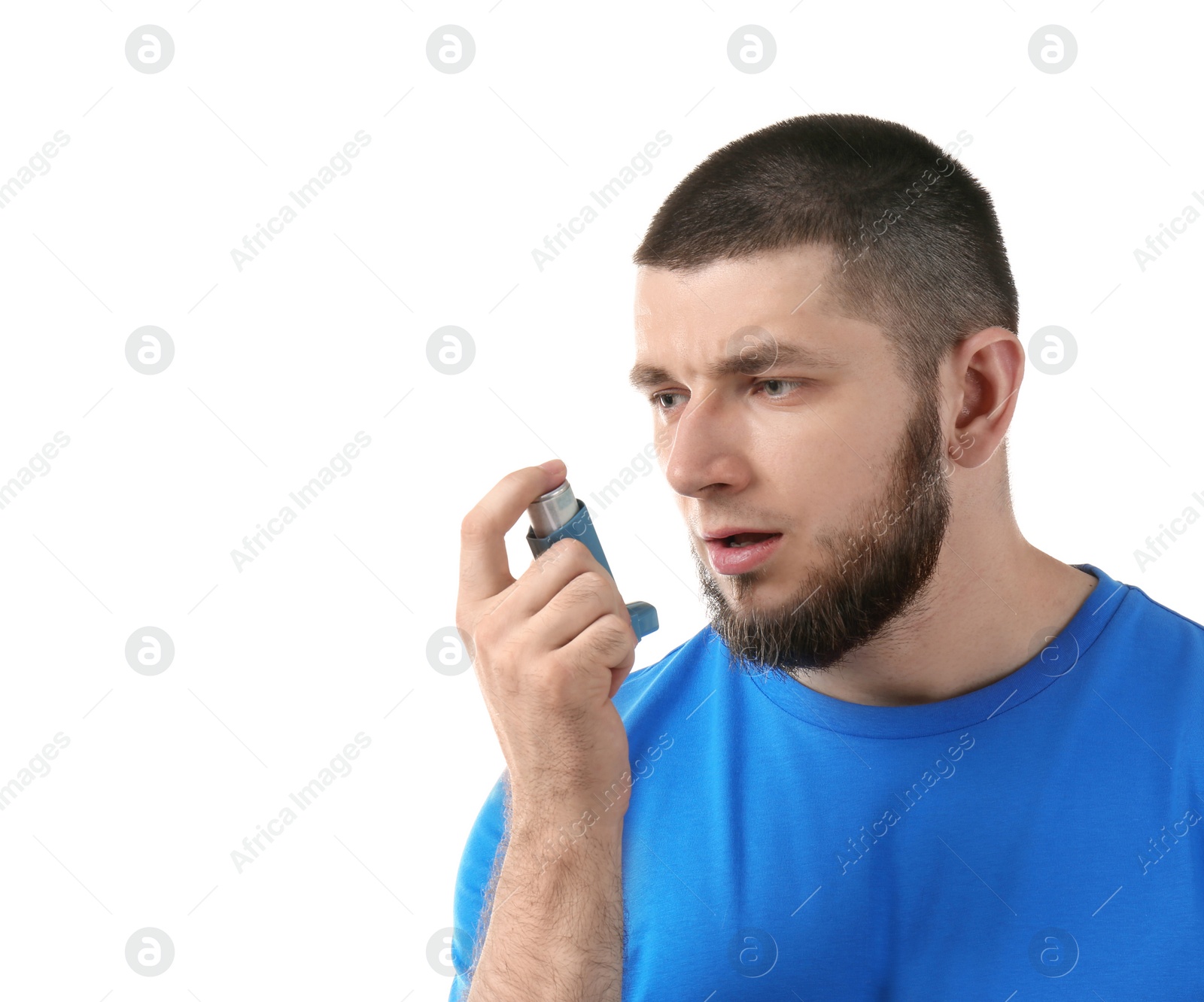 Photo of Young man using asthma inhaler on white background