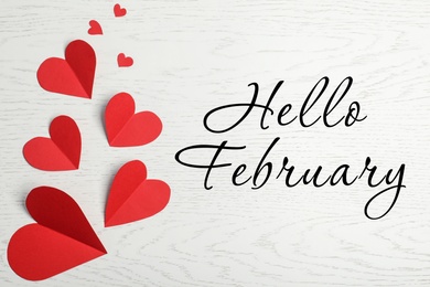 Image of Greeting card with text Hello February. Red paper hearts on white wooden background, flat lay