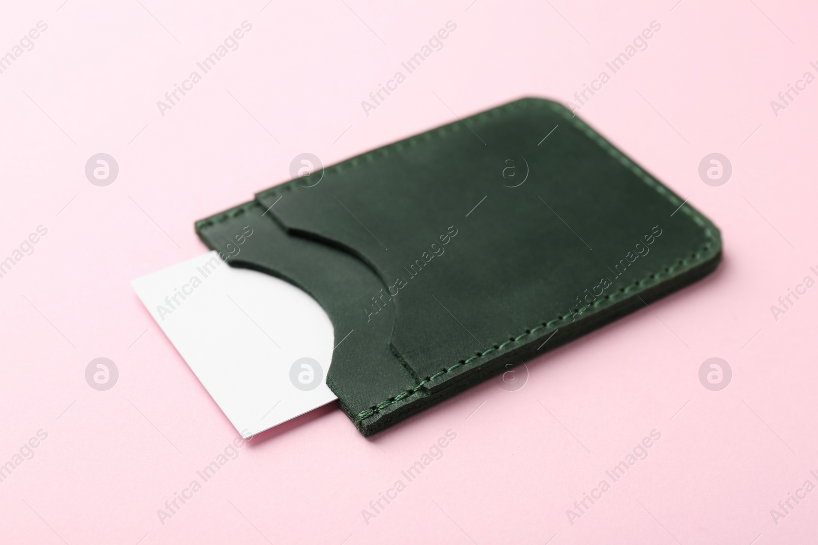 Photo of Leather business card holder with blank card on pink background