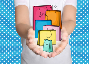 Image of Online shopping. Woman demonstrating paper bags illustration against blue background with polka dot pattern, closeup