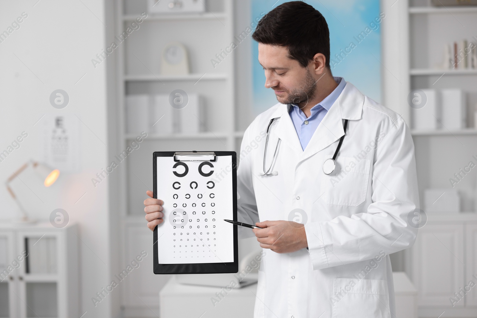 Photo of Ophthalmologist pointing at vision test chart in clinic, space for text