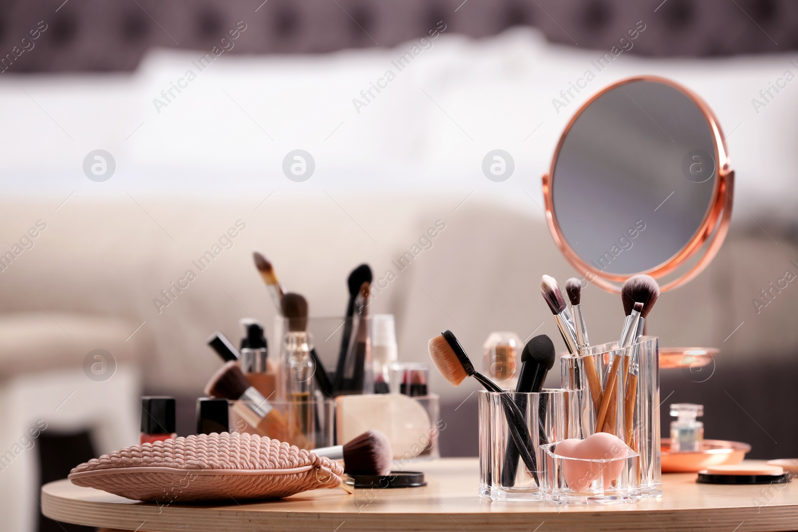 Photo of Makeup accessories and cosmetic products on table against blurred background. Space for text