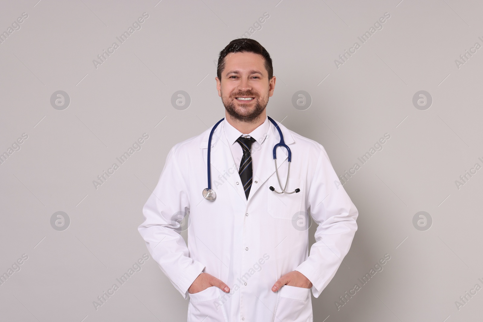 Photo of Portrait of smiling doctor on light grey background