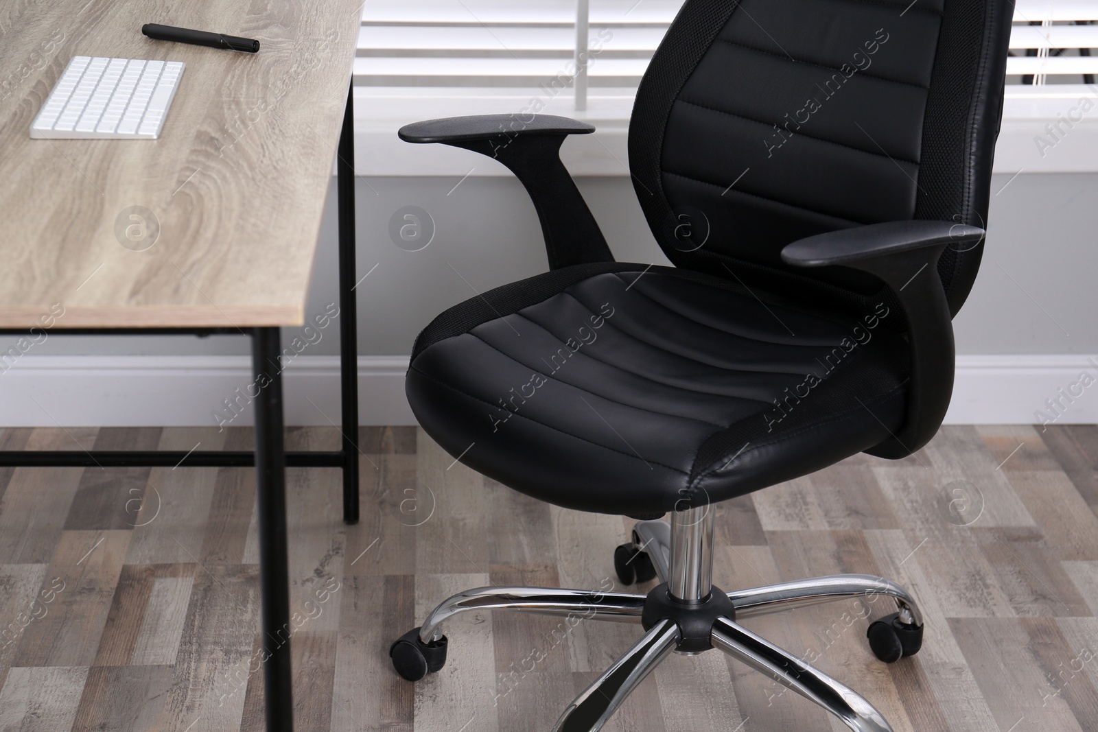 Photo of Comfortable office chair near table in room