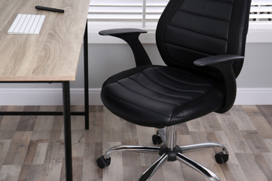 Comfortable office chair near table in room