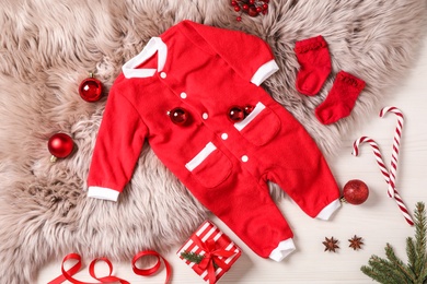 Photo of Flat lay composition with cute Christmas baby clothes on white wooden background
