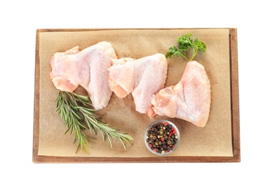 Board with raw chicken wings and spices on white background, top view. Fresh meat