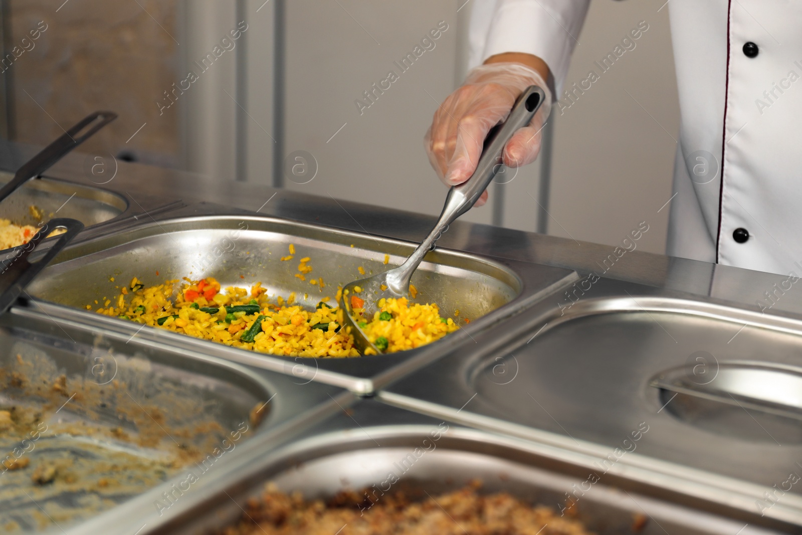 Photo of School canteen worker at serving line, closeup. Tasty food