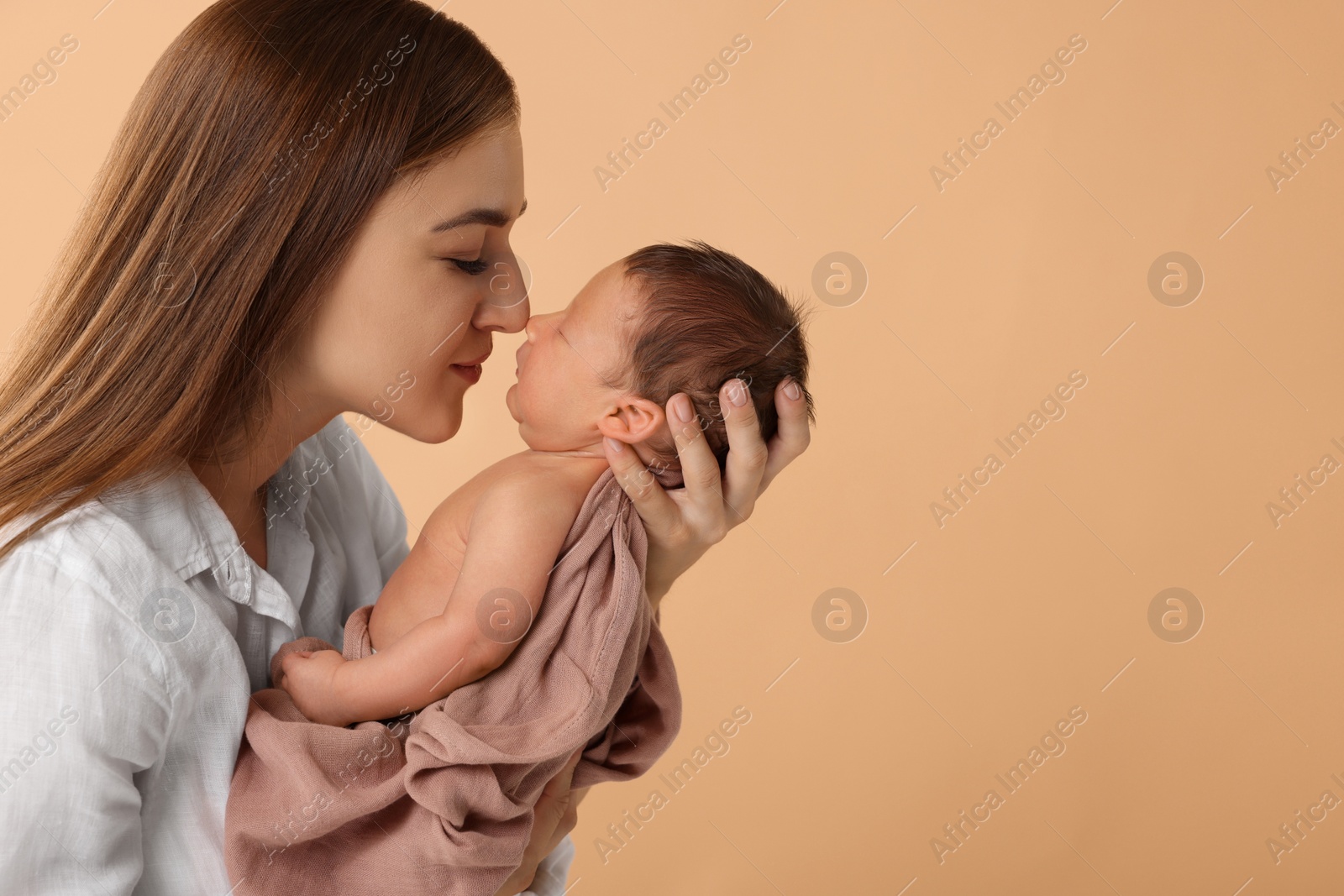 Photo of Mother with her cute newborn baby on beige background. Space for text