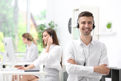 Photo of Young male receptionist with headset in office