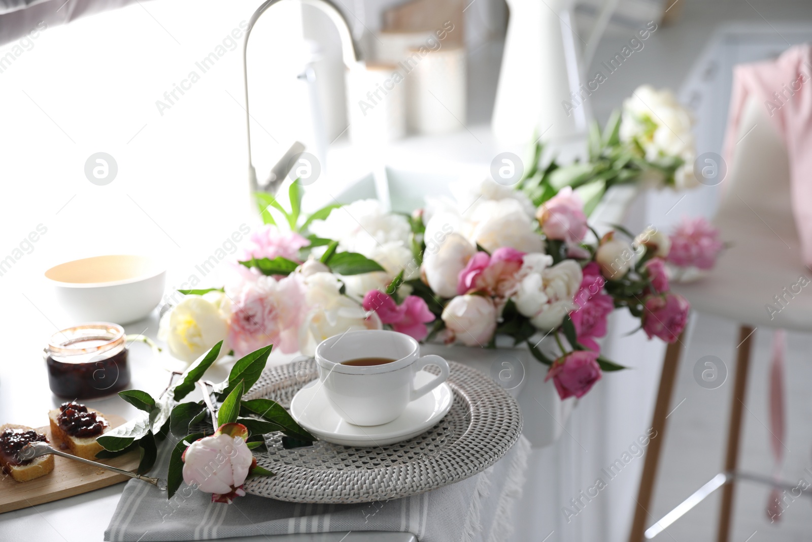 Photo of Beautiful peonies and breakfast on kitchen counter