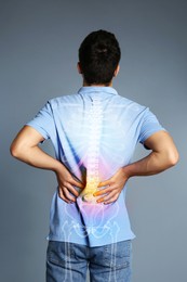 Man having backache on grey background. Digital compositing with illustration of spine 