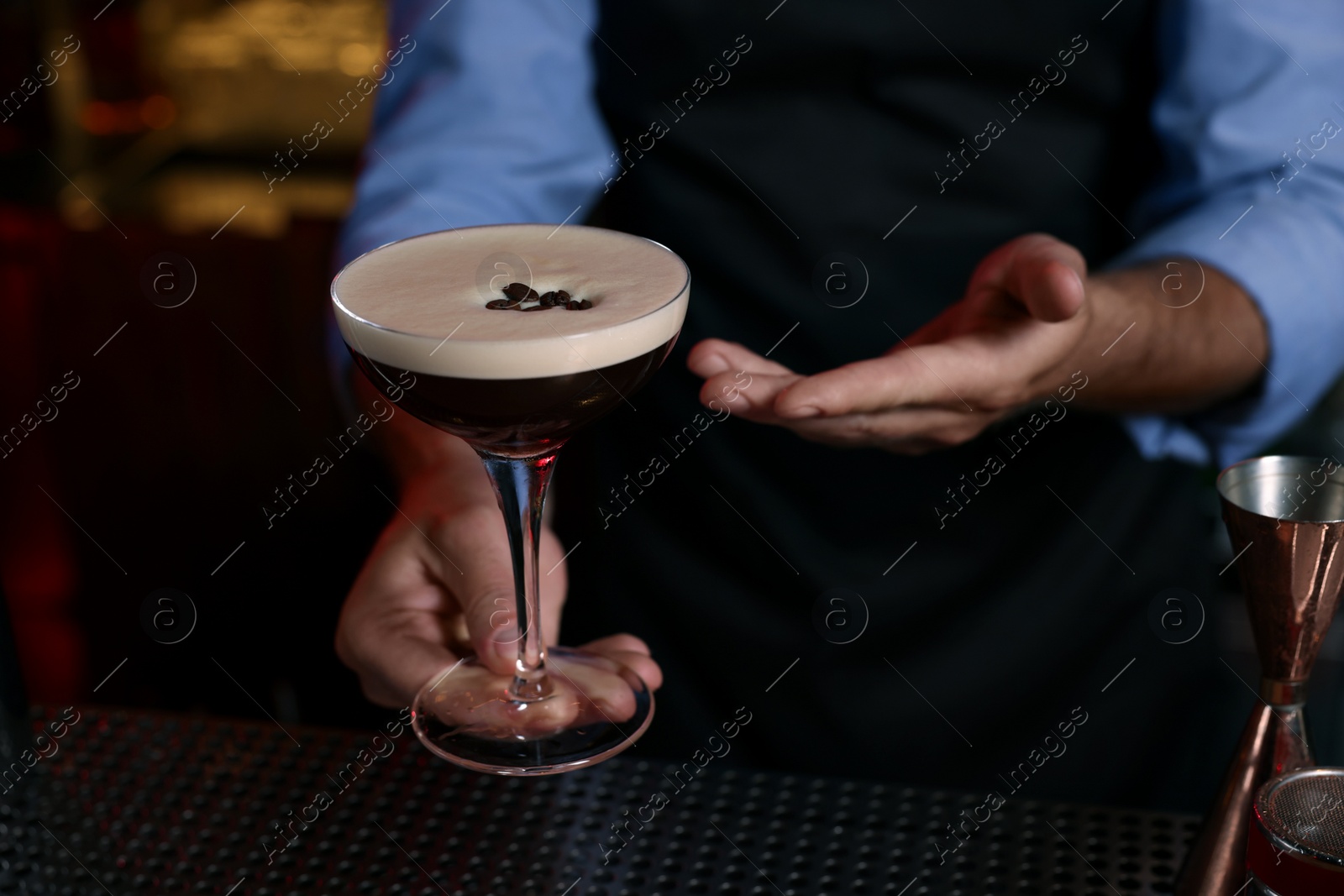 Photo of Bartender with Espresso Martini in bar, closeup. Alcohol cocktail