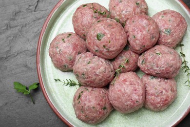 Many fresh raw meatballs on black table, flat lay