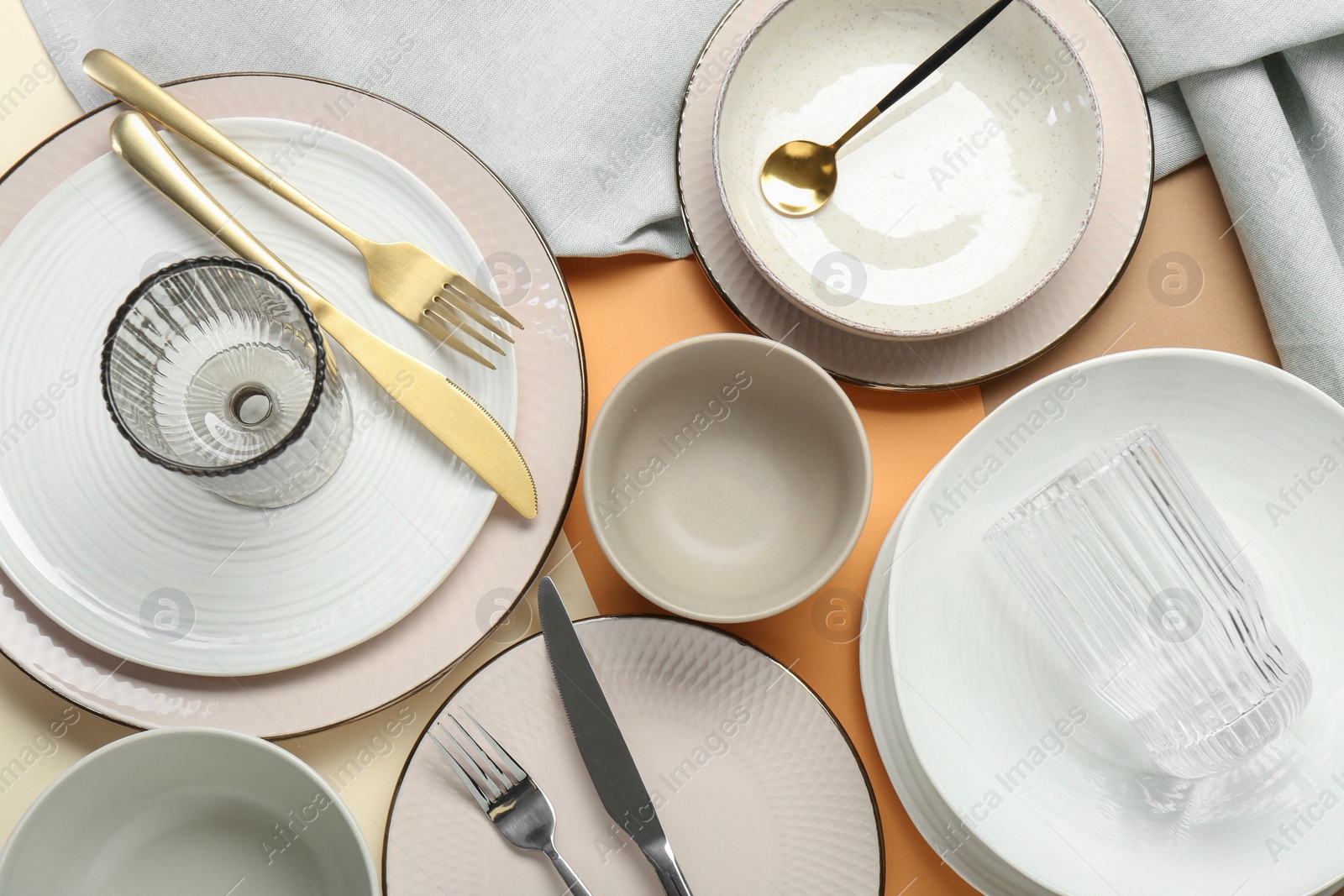 Photo of Clean plates, bowls, glasses and cutlery on table, flat lay