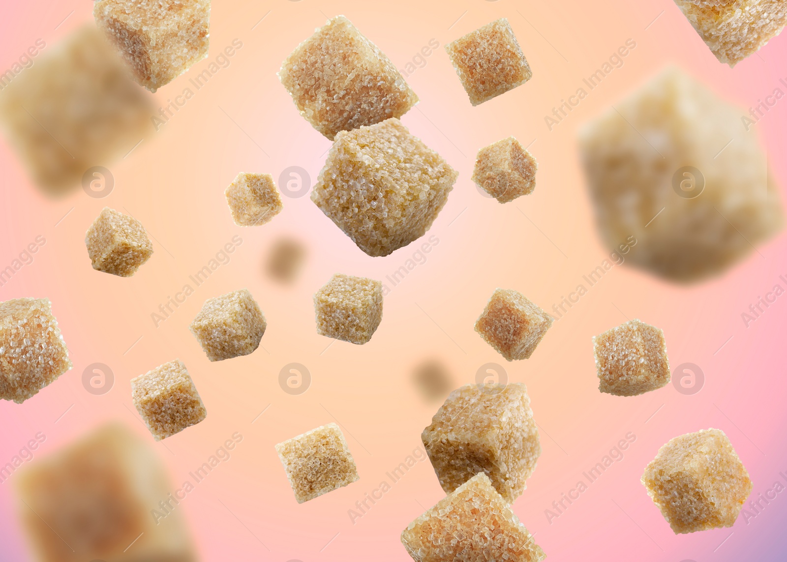 Image of Brown cane sugar cubes falling on color gradient background