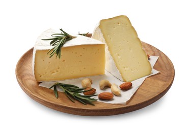 Photo of Plate with pieces of tasty camembert cheese, nuts and rosemary isolated on white