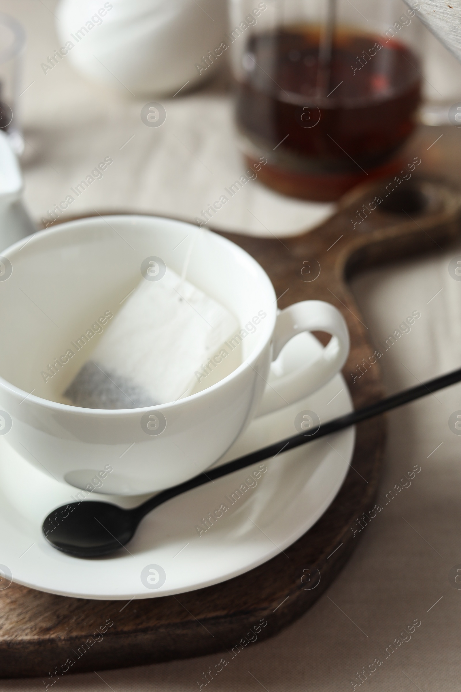 Photo of Tea bag in cup on light table, closeup