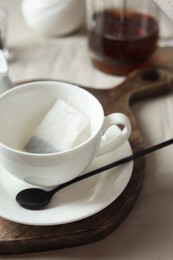 Photo of Tea bag in cup on light table, closeup