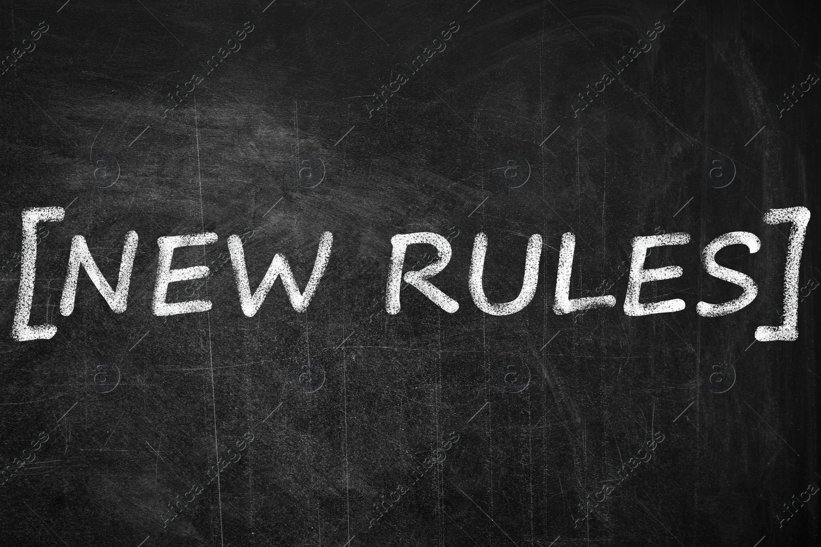 Image of Text NEW RULES written on black chalkboard