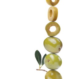 Cut and whole green olives with leaves on white background