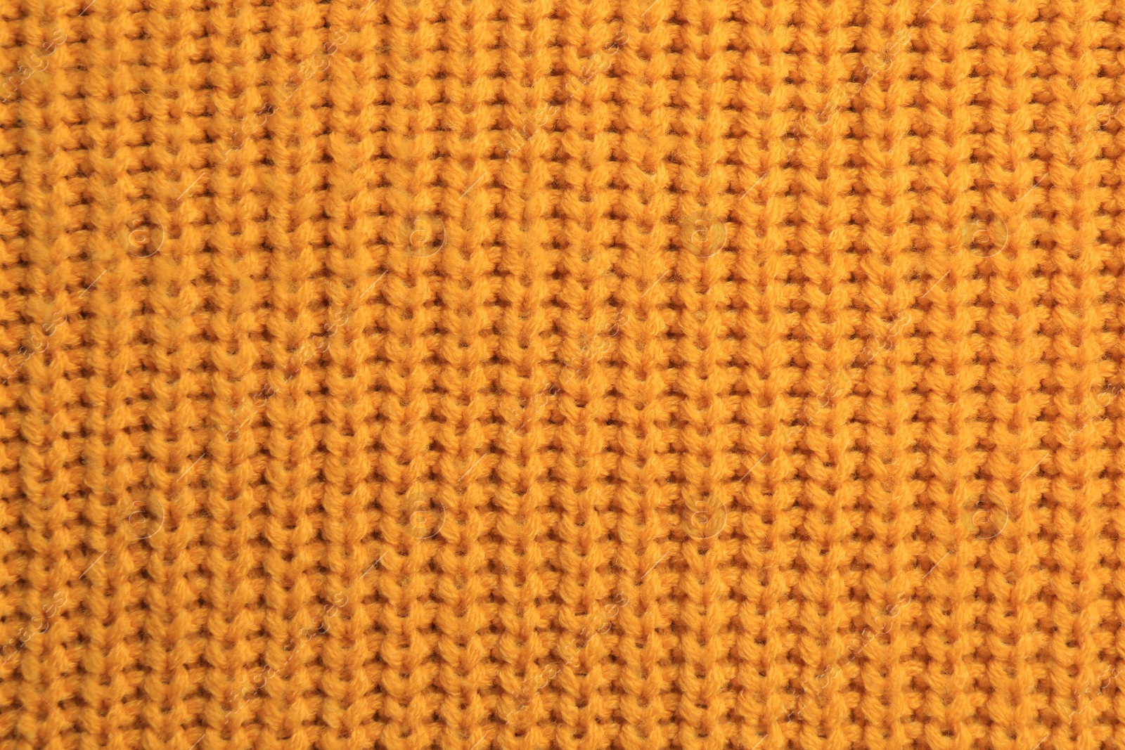 Photo of Beautiful orange knitted fabric as background, top view