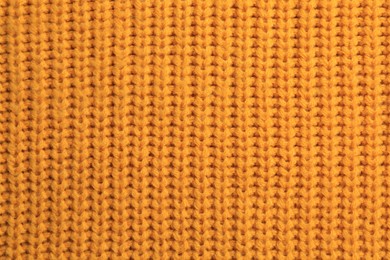 Beautiful orange knitted fabric as background, top view