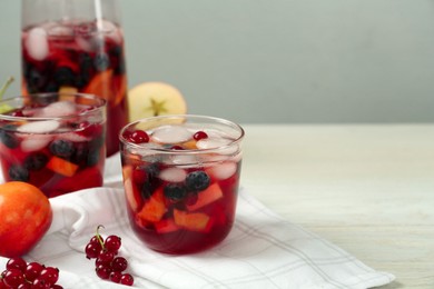 Delicious Red Sangria and ingredients on white wooden table, space for text