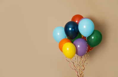 Photo of Bunch of bright balloons on color background, space for text. Celebration time