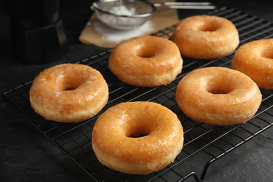 Photo of Sweet delicious glazed donuts on black table