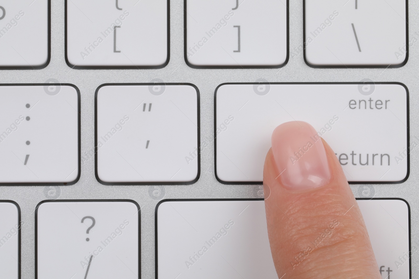 Photo of Top view of woman pressing button on computer keyboard, closeup