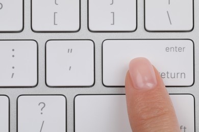 Photo of Top view of woman pressing button on computer keyboard, closeup