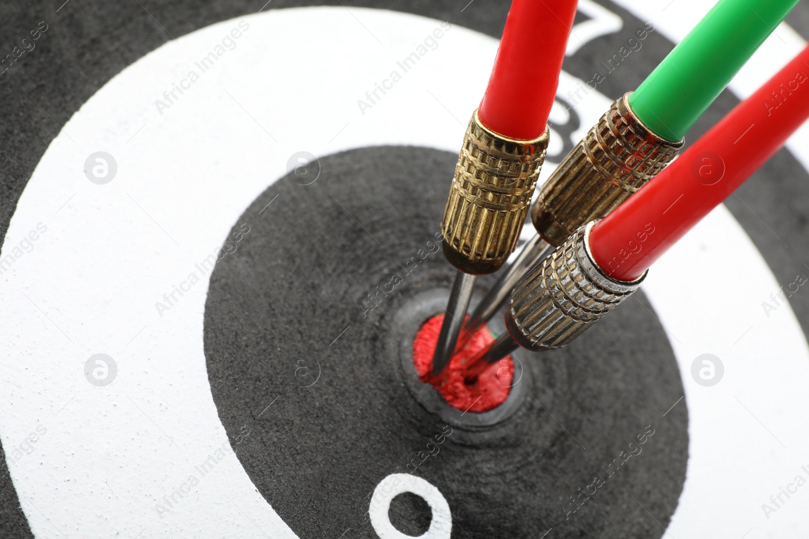 Photo of Dart board with color arrows hitting target, closeup