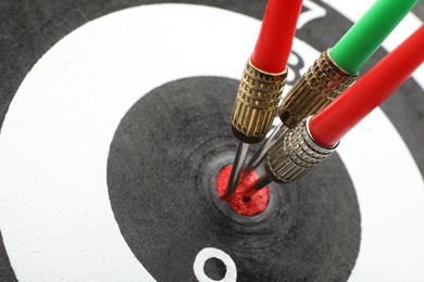 Dart board with color arrows hitting target, closeup